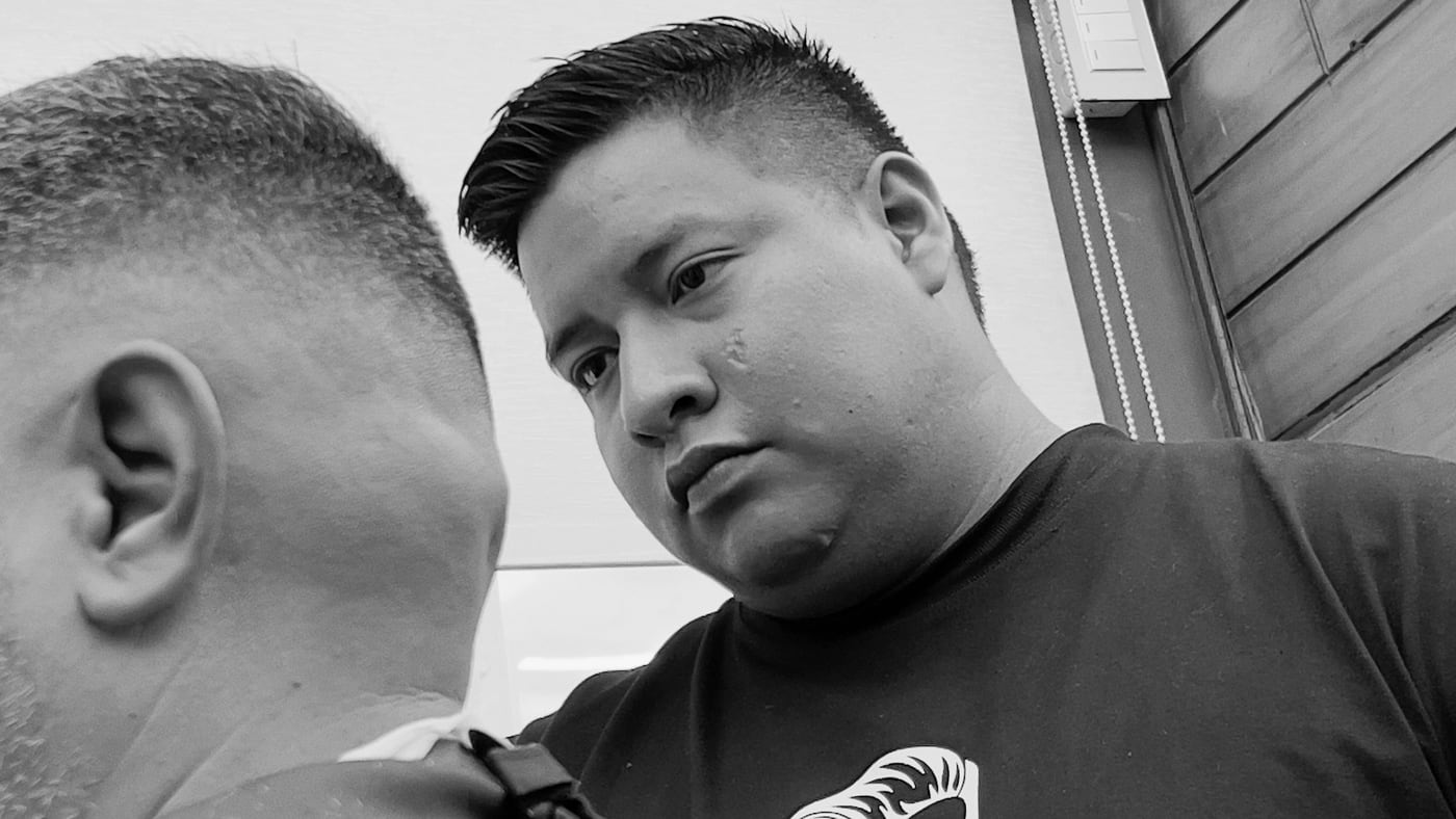 Barbero de Ron Barbershop trabajando durante un servicio.