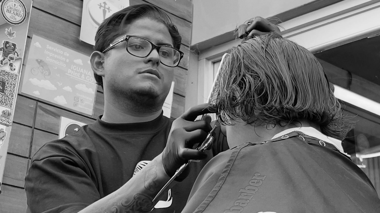 Barbero de Ron Barbershop cortando el cabello de un cliente.